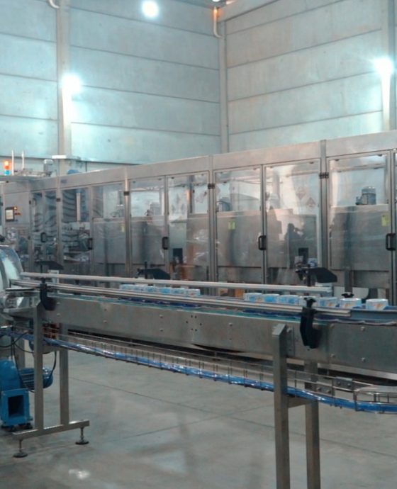 Aplicadora de sleeves IMEK em operação em linha de produção industrial, aplicando rótulos termorretráteis com precisão e alta velocidade