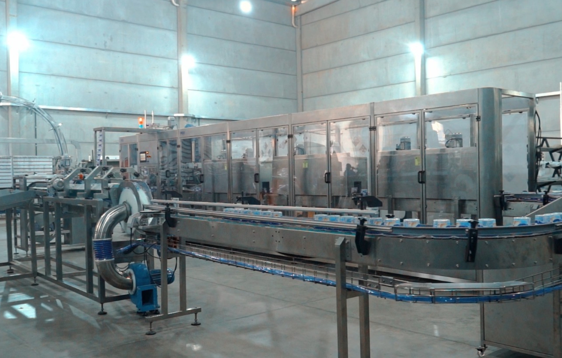 Aplicadora de sleeves IMEK em operação em linha de produção industrial, aplicando rótulos termorretráteis com precisão e alta velocidade