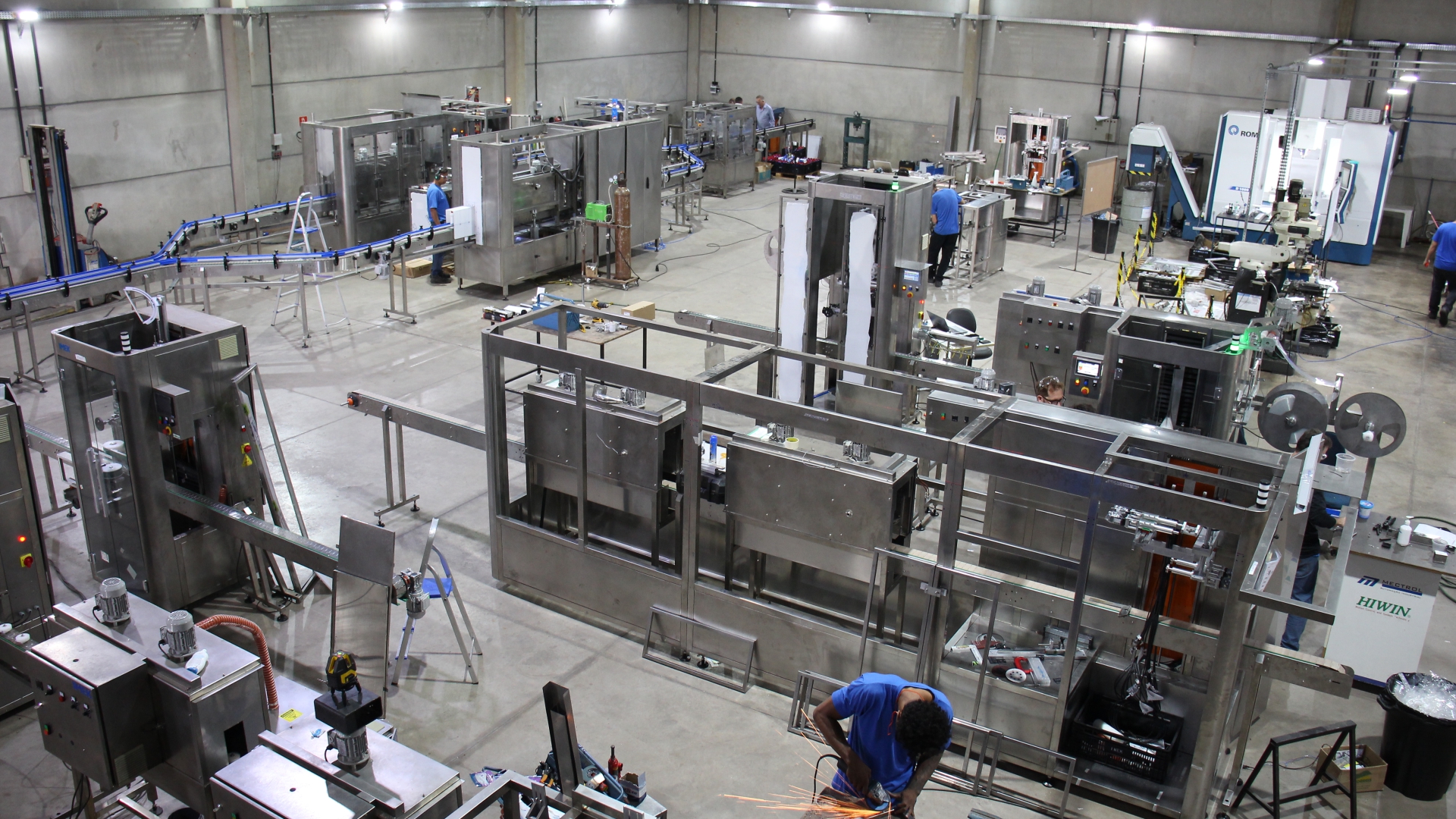 Aplicadora de sleeves IMEK em operação em linha de produção industrial, aplicando rótulos termorretráteis com precisão e alta velocidade